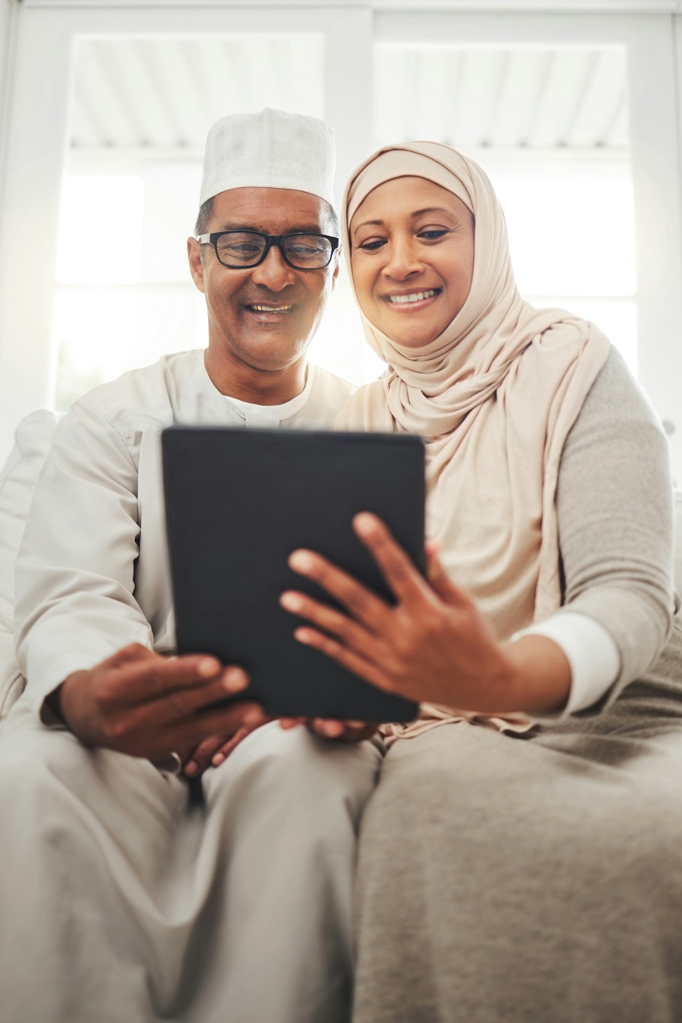 Tablet video call, Muslim and happy elderly couple talking, speaking and on online communication. G